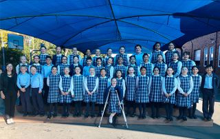 St Therese catholic Primary School Student Showcase choir students standing on outdoor stage smiling
